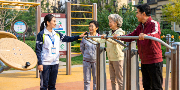 社会体育指导员在社区指导居民使用健身器材 - 专业教学场景