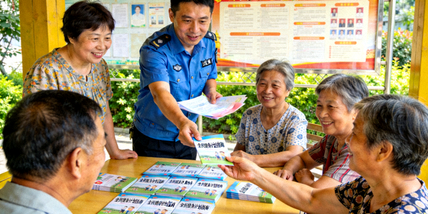 社区工作人员向居民讲解全民健身计划政策，现场发放指南手册