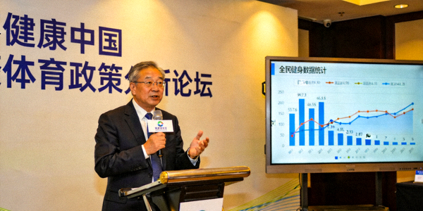 专家在论坛上分析健康中国体育政策，背景显示全民健身数据图表