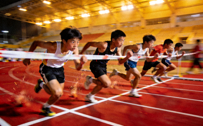 青少年男子100米短跑决赛冲刺瞬间 - 多名运动员全力冲过终点线