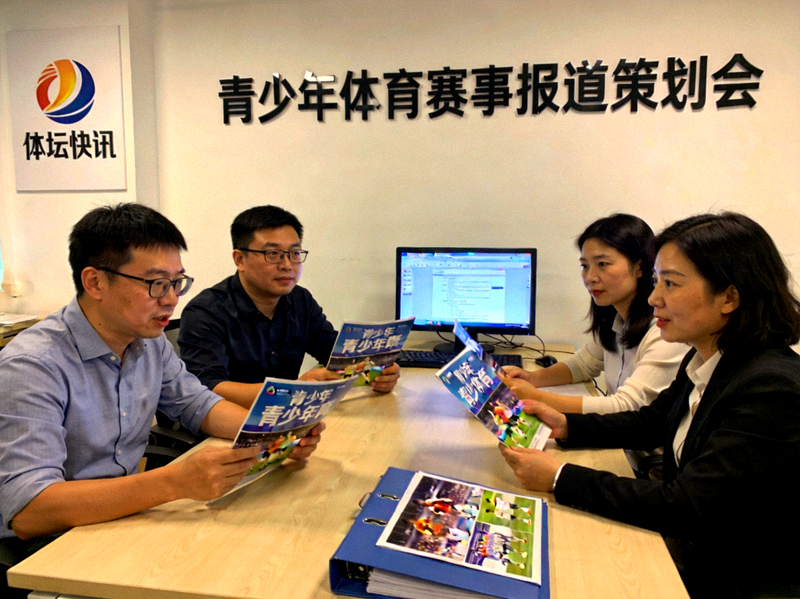 体坛快讯团队工作场景 - 编辑们在讨论青少年体育赛事报道